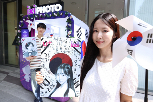 LG유플러스가 광복절을 맞아 서울 마포구 공덕역점에 광복절 콘셉트의 AI 프로필 사진을 제작해주는 '익시 포토부스'를 선보였다. 모델이 부스를 소개하고 있다. LG유플러스 제공